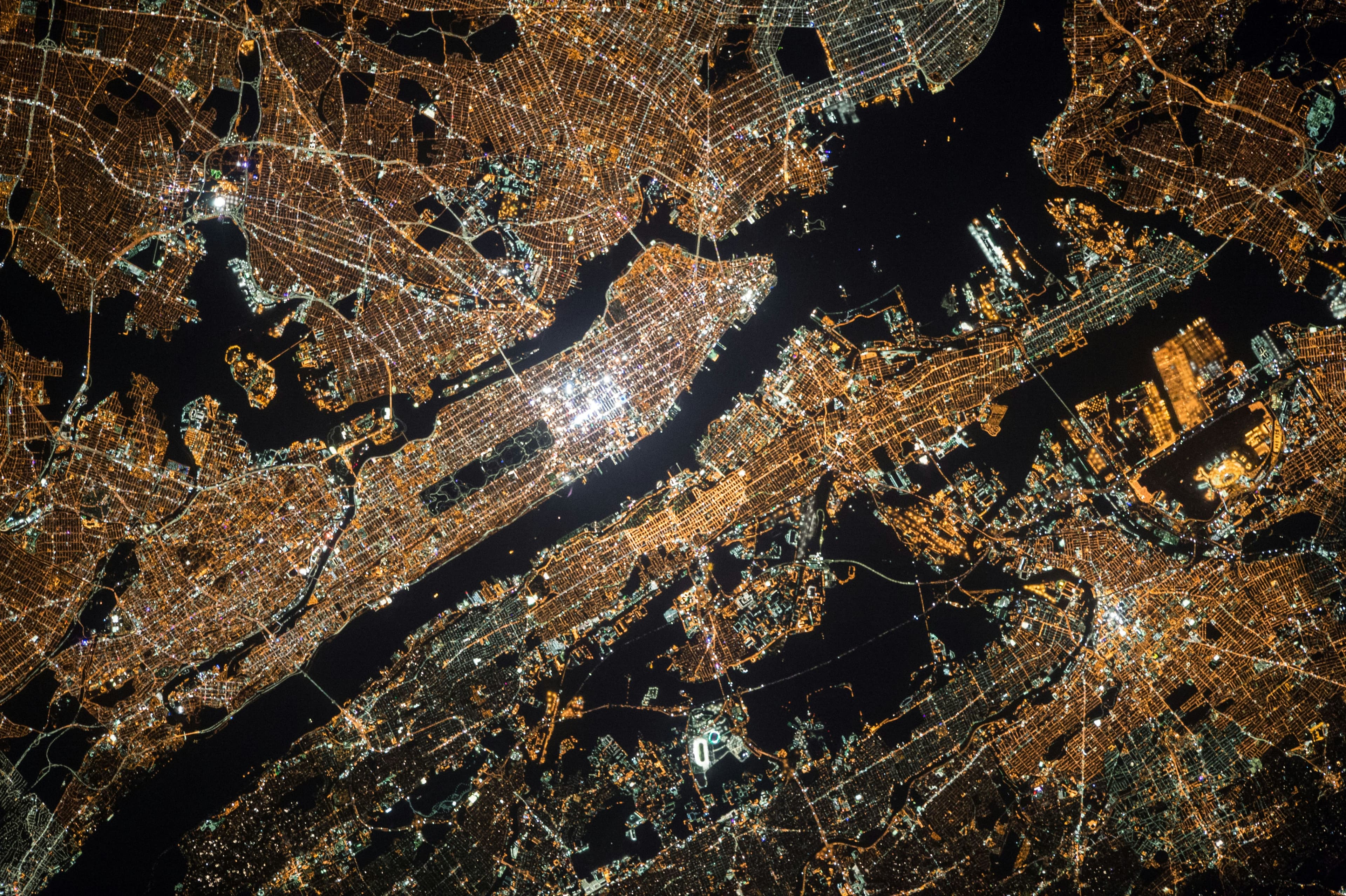 Nighttime city grid from above representing networked business services and operational scale