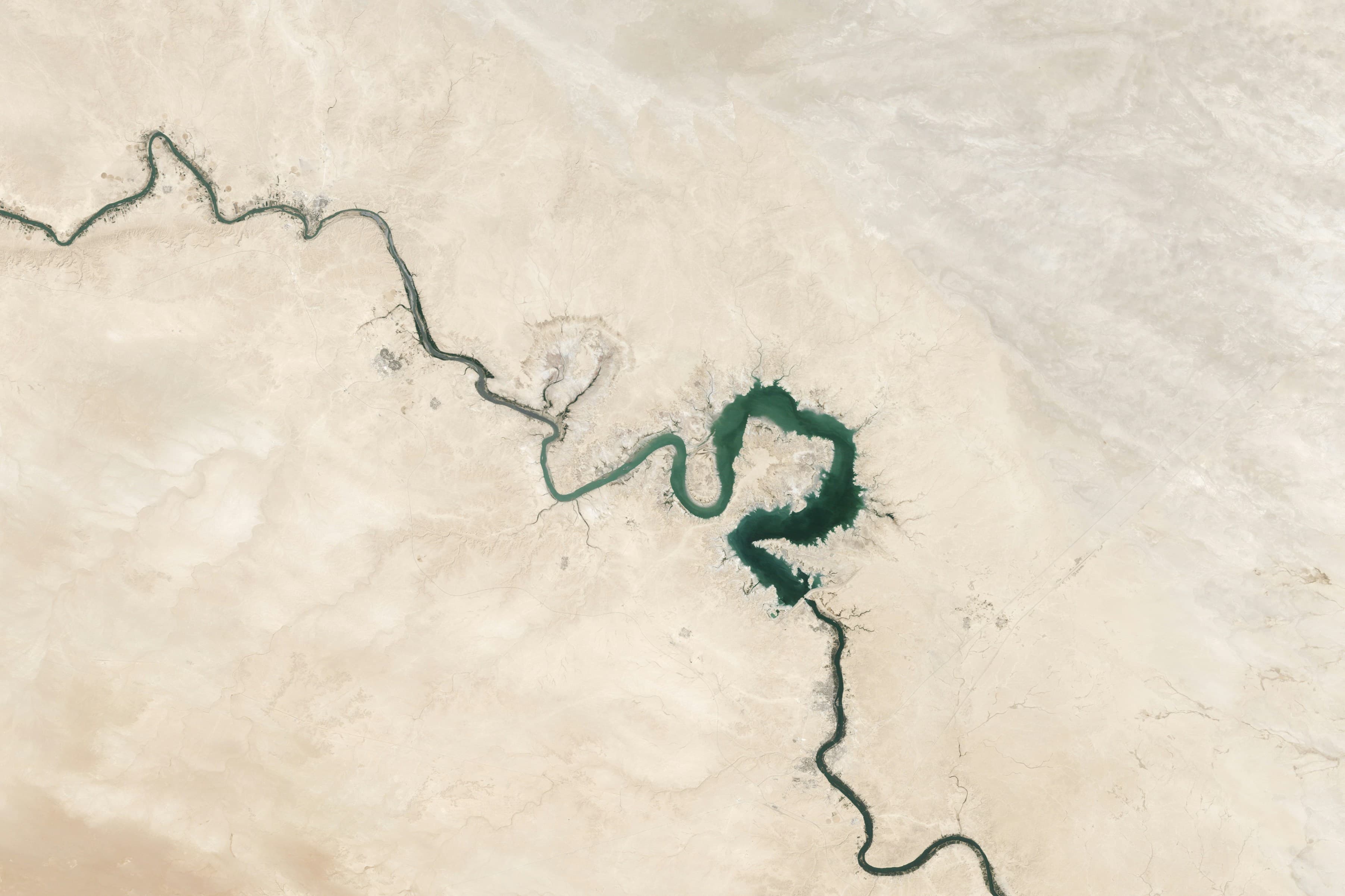 A winding river path from above representing owner transition planning and long-term continuity